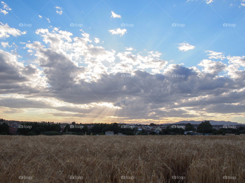 Landscape, sky with clouds and sun rays that illuminate the village