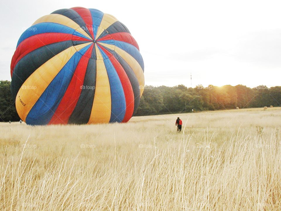 A hot air balloon pre-flight. A lone witness watches a hot air balloon inflate in a rural farm field in the south of France 