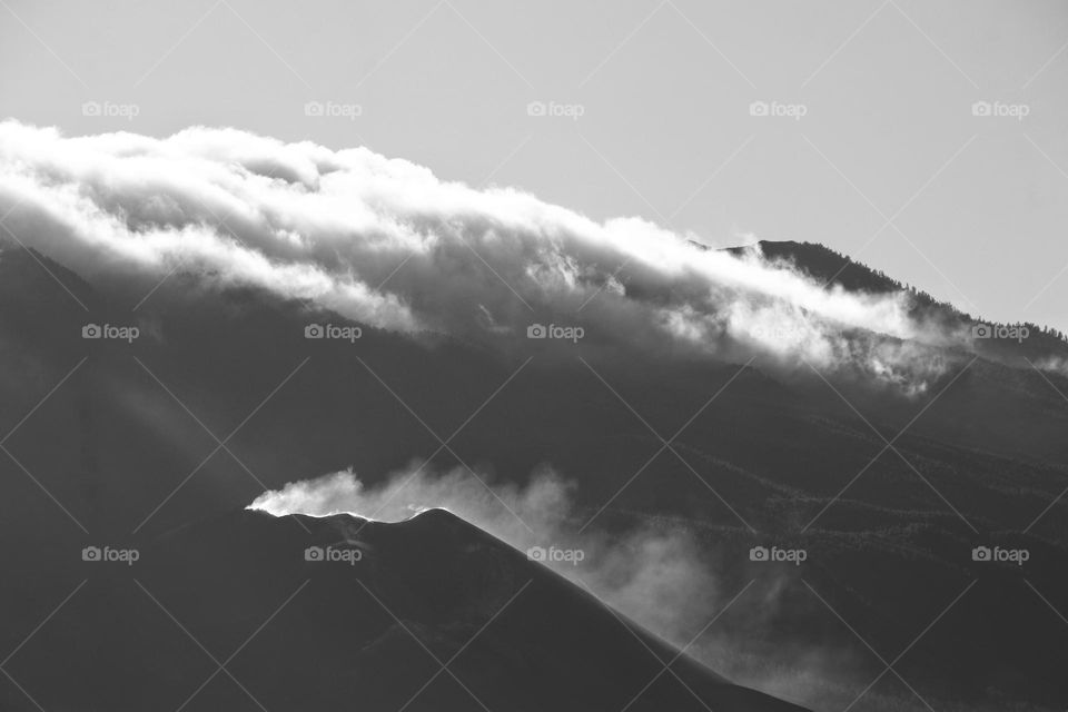 The Tajogaite volcano on La Palma surrounded by clouds and smoke in black and white