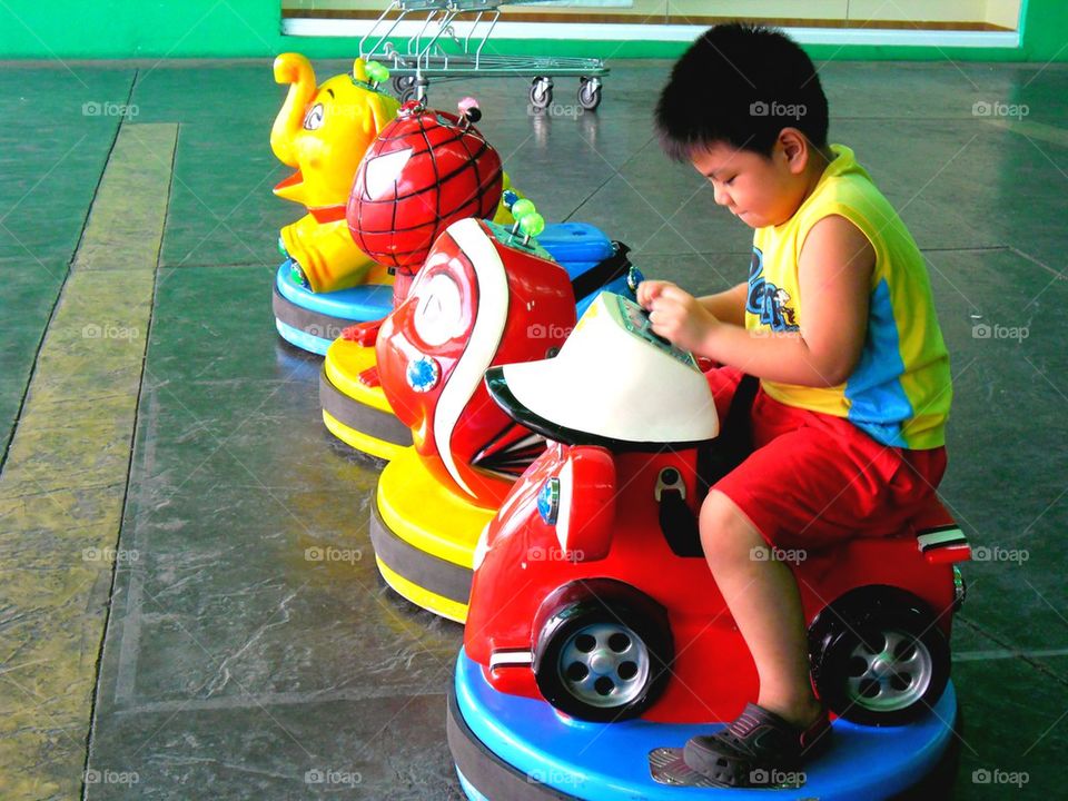 young asian boy on kiddie rides