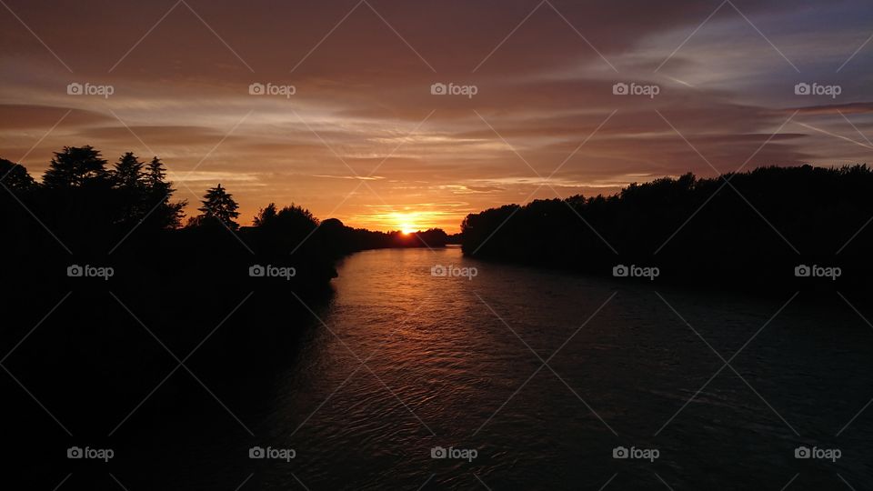 wonderful Italian sunset, river, sun and forest