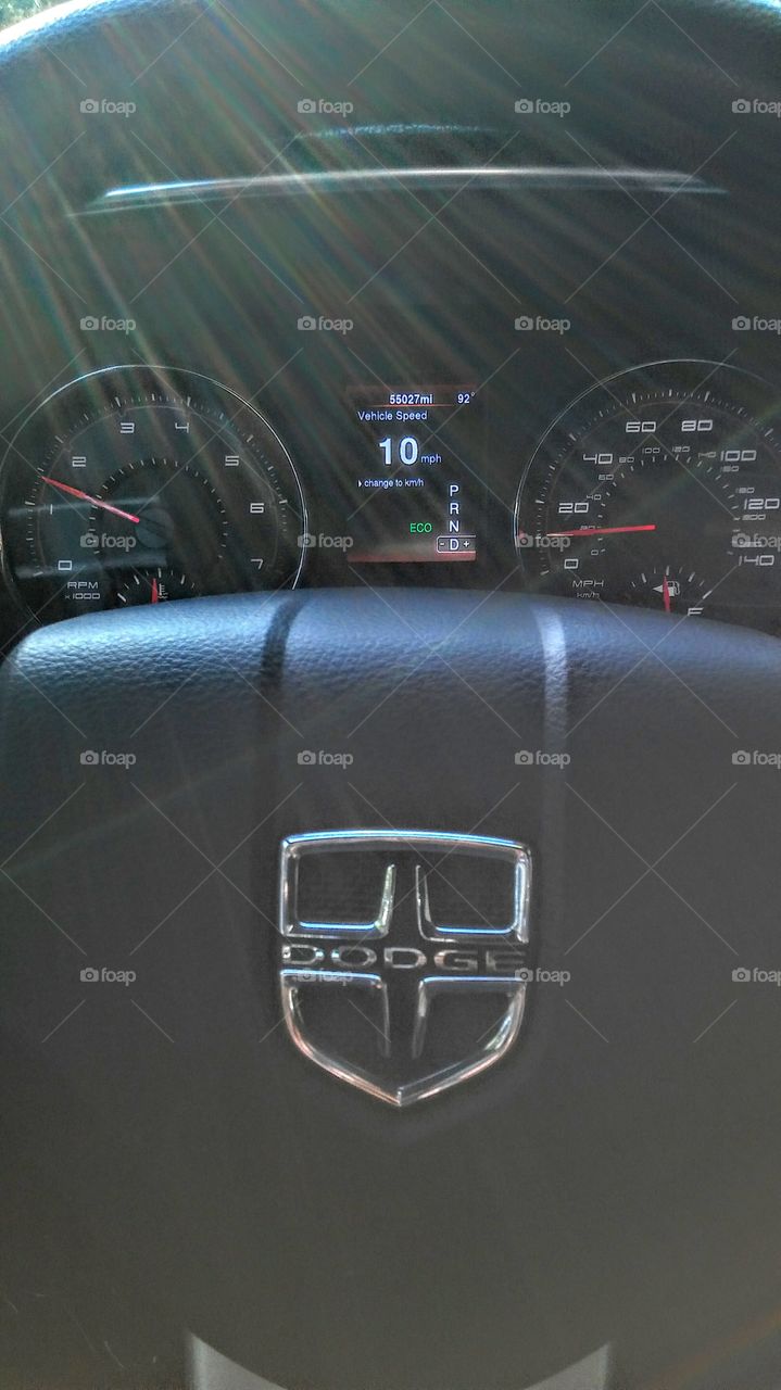 sunrays over a dashboard steering wheel