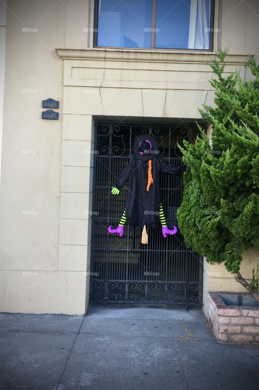 Little witch Halloween decoration on house entrance 