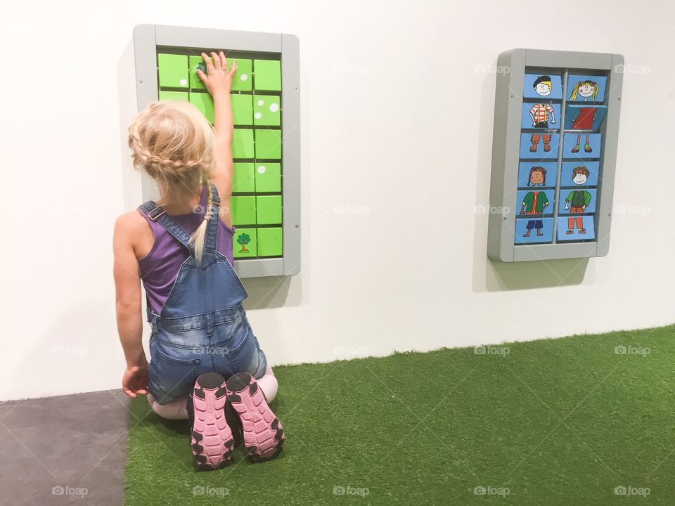 Young girl playing memory at a playground at a mall in Sweden.