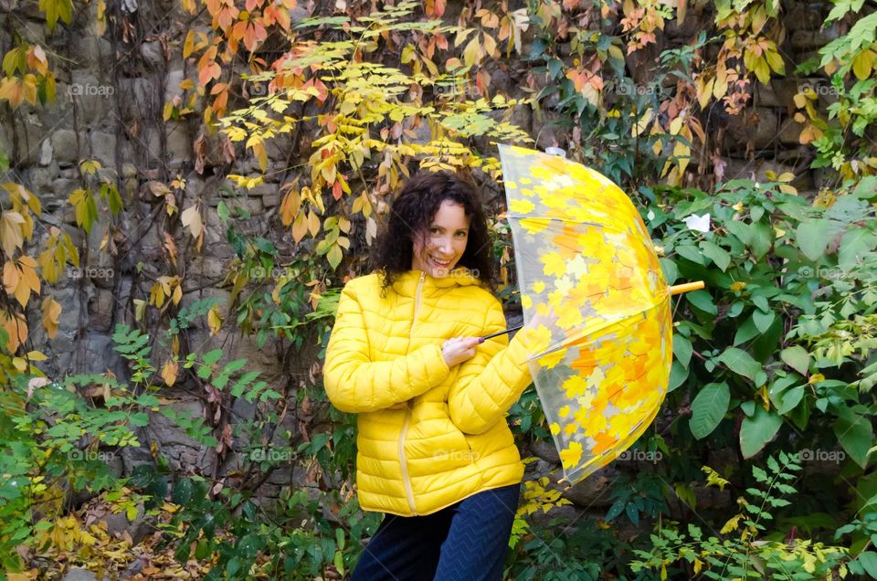 Smiling Woman with Umbrella on Autumn Background