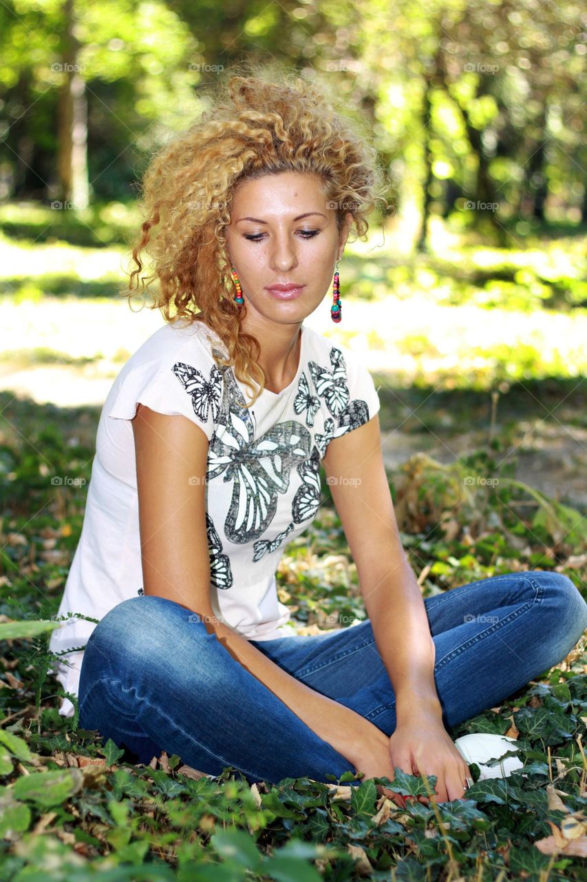 Beautiful woman sitting on grassy land