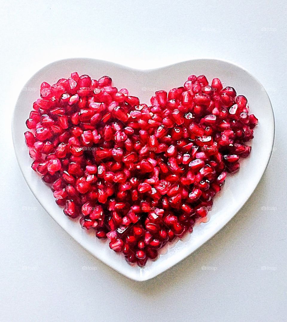 Pomegranate seeds in heart shaped plate 