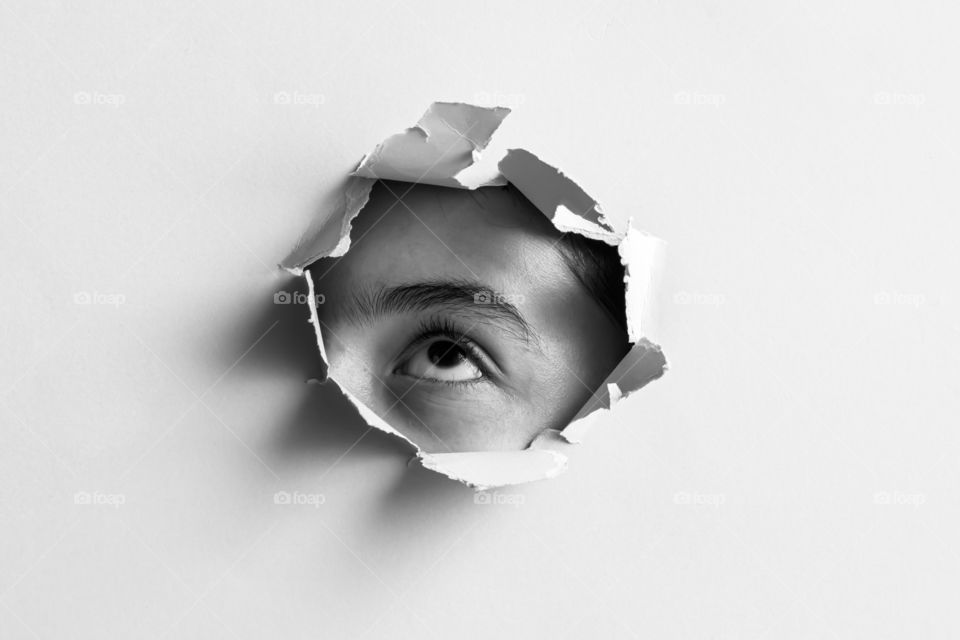 Child looking up through the paper hole. Abstract image.