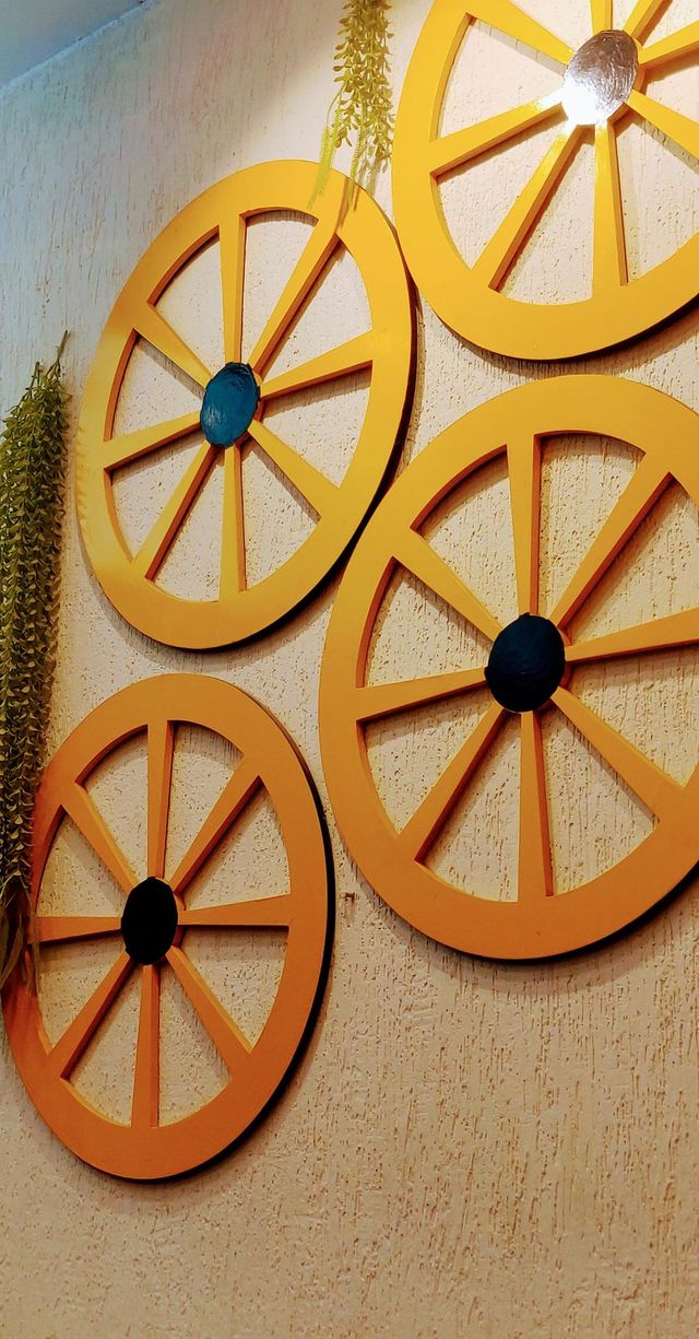 A beautiful coffee cafe wall decorated with an old time wheel design.  The beautiful yellow colored wheels are enhancing the beauty of the wall.
