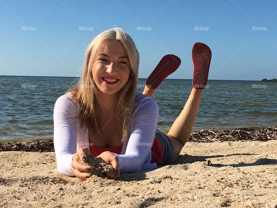 Woman lying on sandy beach