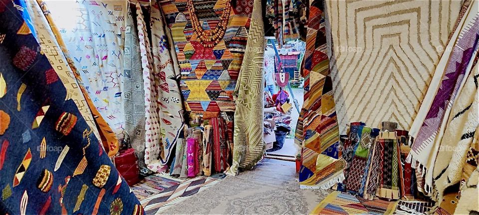 The “Tollwood” summer festival in “Munich”, Bavaria features various music events as well as a market with folklore fare and merchandise from around the World often handmade like these beautiful multifaceted colorful rugs. 2024. Hypnotic Productions