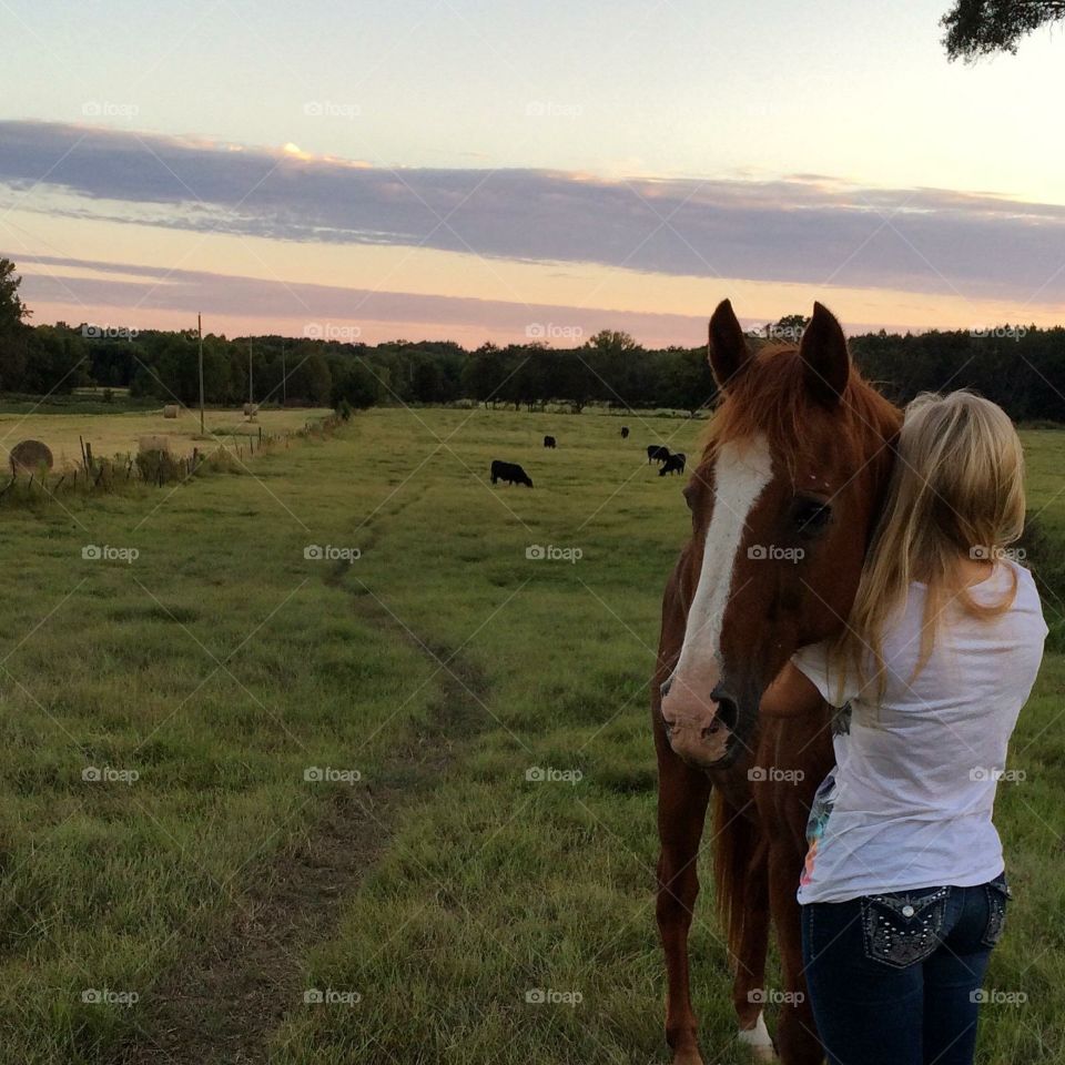 And girl and her horse at sunset