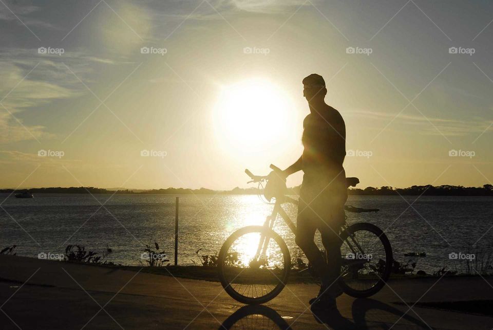 The Special Sunset with  man in a bike in front the river