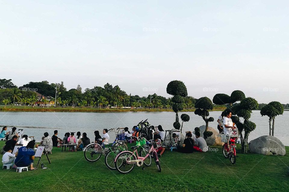 People paint picture near the lake in the psrk as their leisure activity