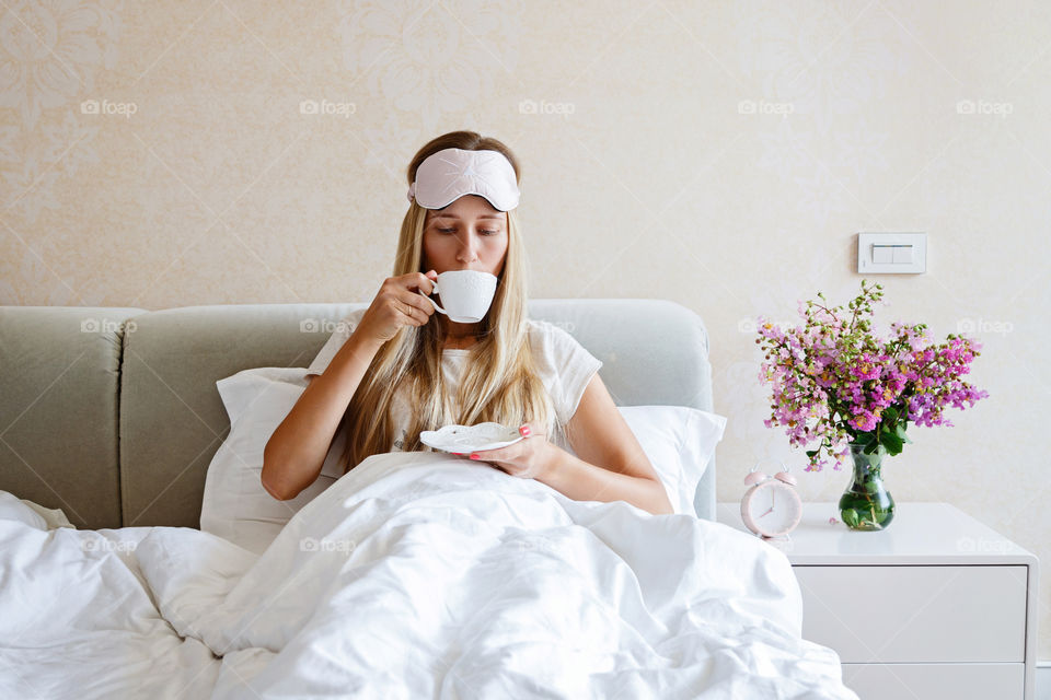 Woman drinking coffee in the bed