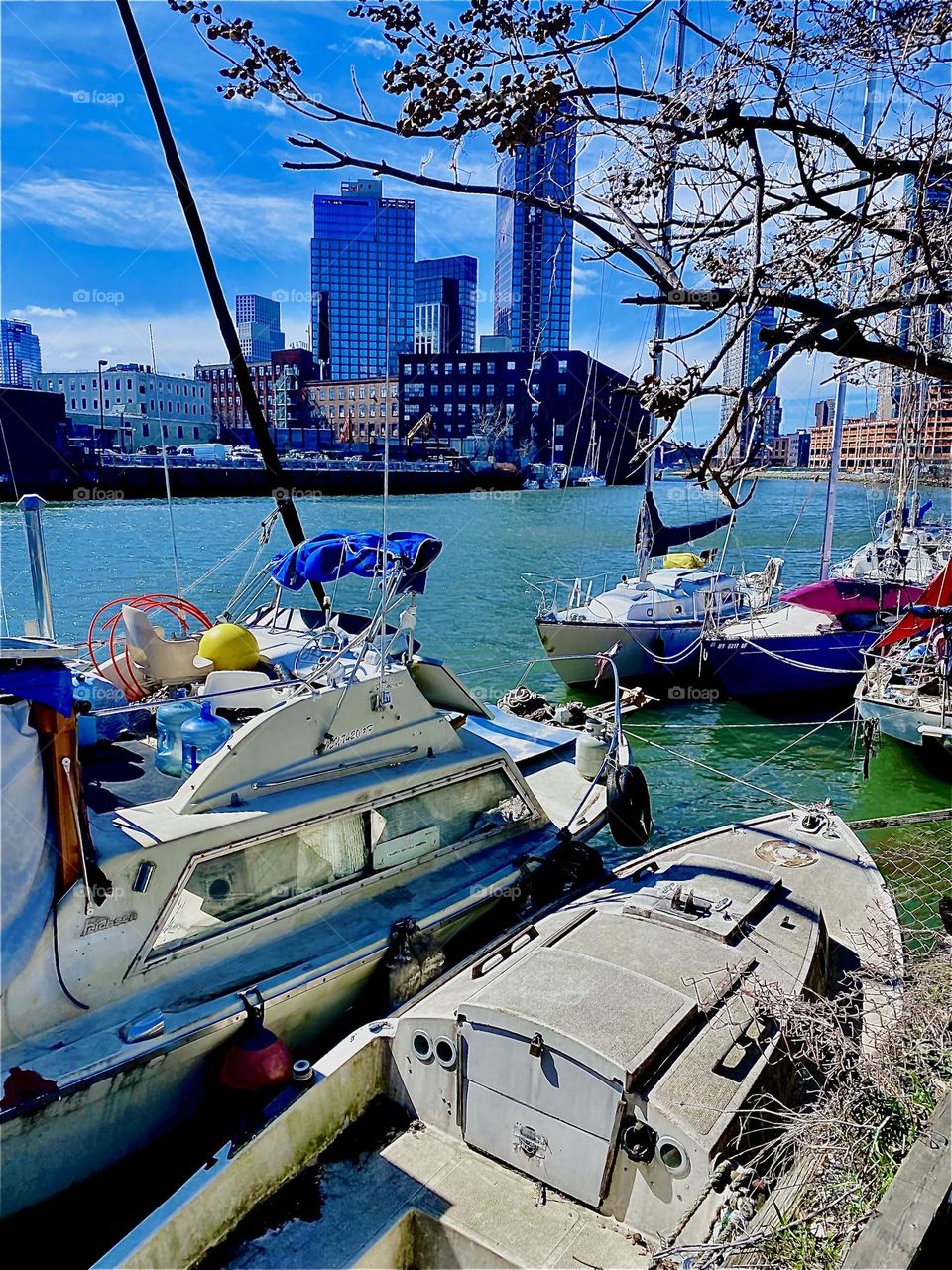 Beautiful accents of color on the decks of the various boats here at “Newtown Creek” by the “Pulaski Bridge” in “Long Island City”, Queens, NY amongst other things make this photograph a winner. 2023. Hypnotic Productions
