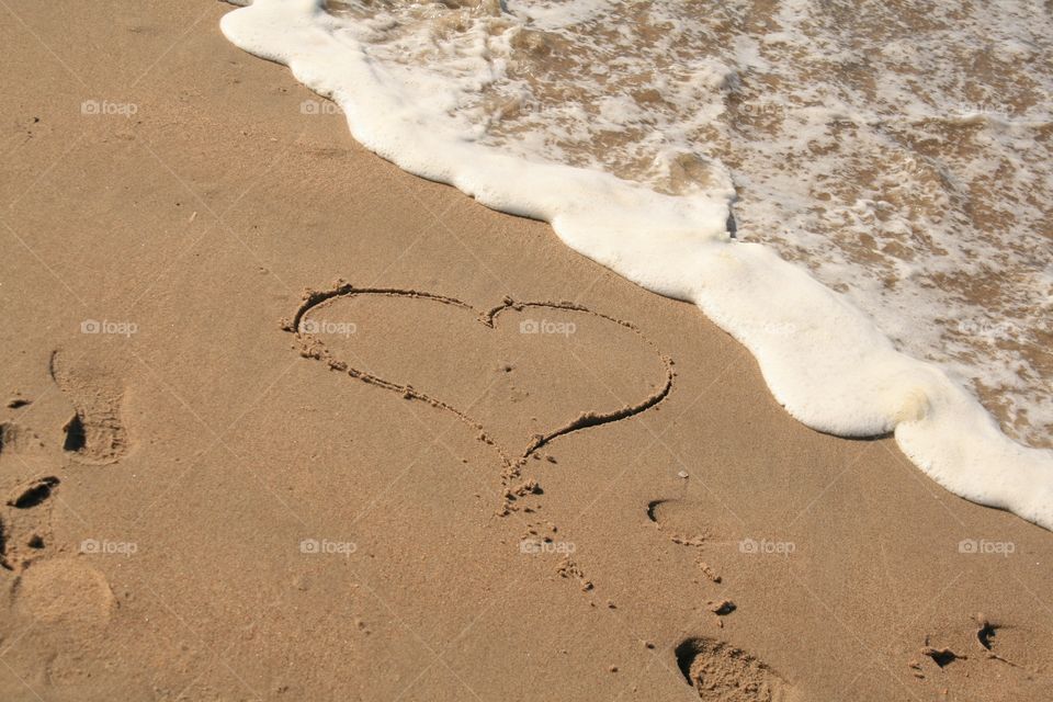 A heart drawn in the sand on the beach