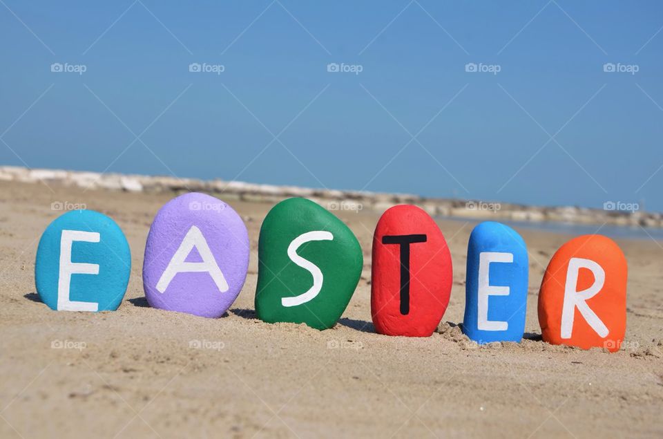 Easter concept on colourful stones with beach background