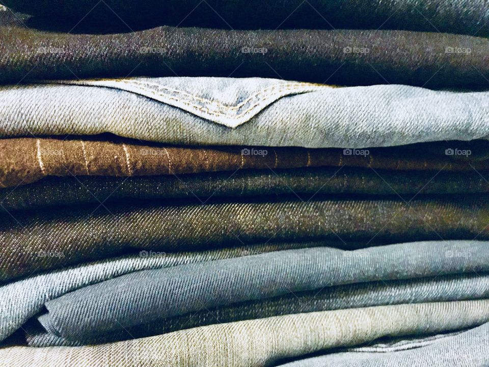 A pile of jeans in different colours