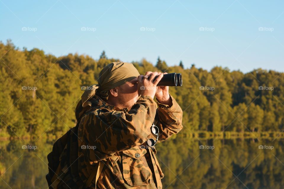 A man looks through binoculars