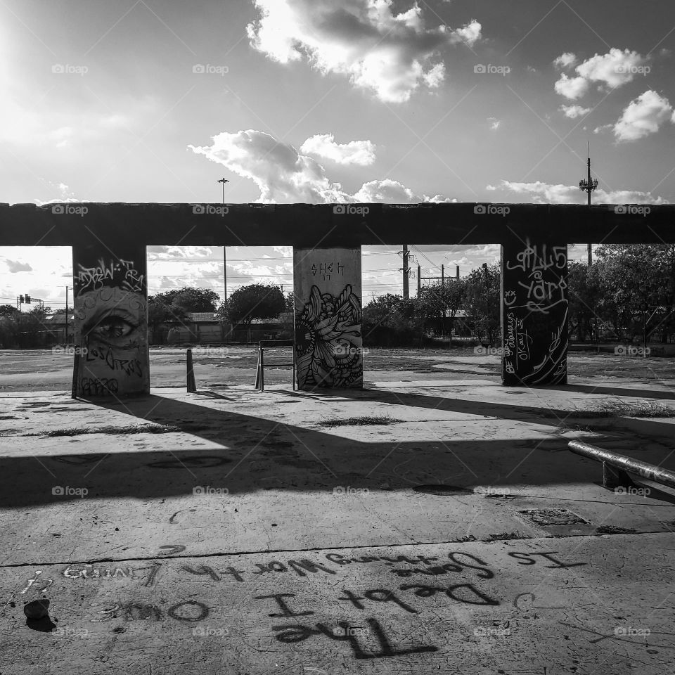 The debt I owe... in black and white. Urban street art and graffiti at an abandoned deteriorated facility as the sun sets creating shadows.