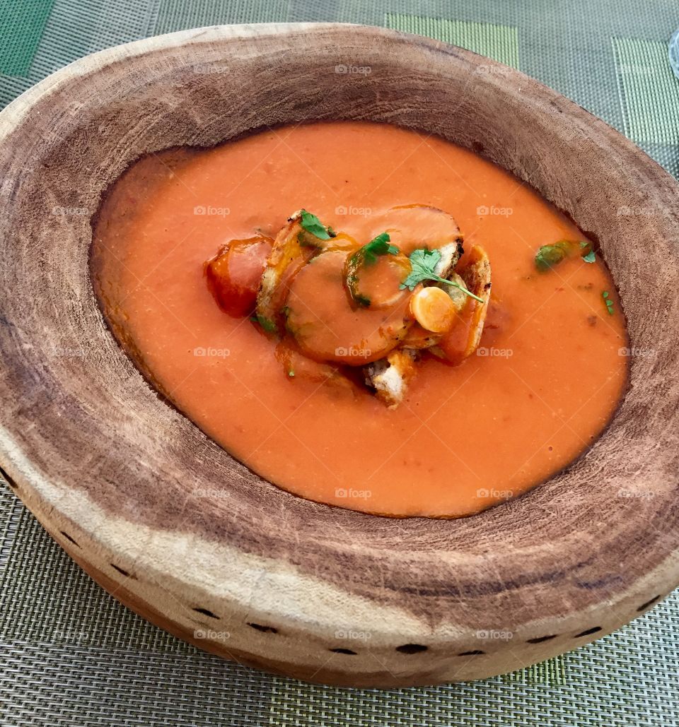 Tomato soup in wood bowl