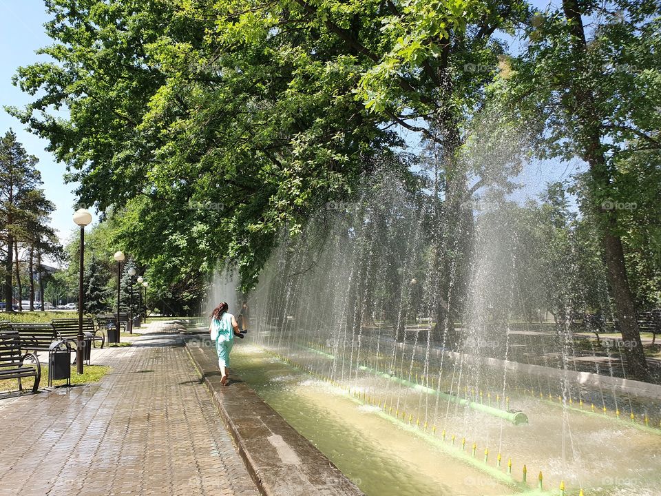 girl walking near fontain in the park