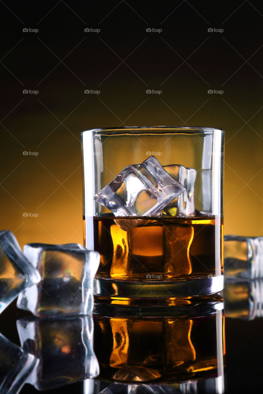 Whisky, rum or a glass of cold drink with ice cubes