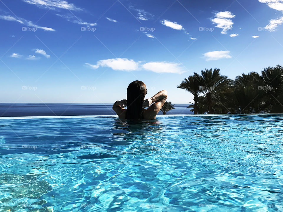 Enjoying the last summer days in the swimming pool above the sea 