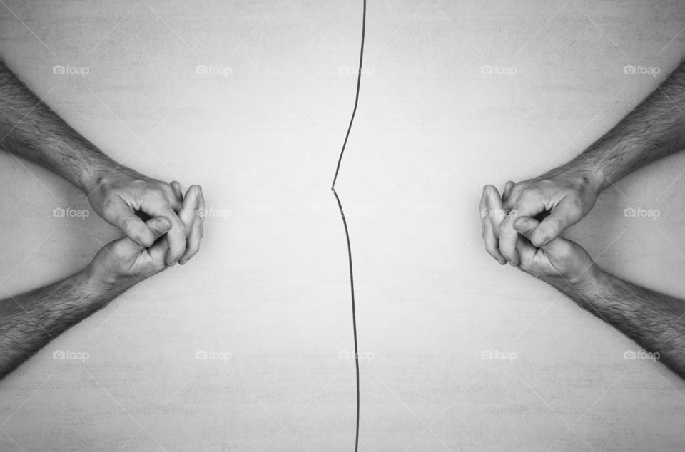 hands of two men on against each other and a crack between them