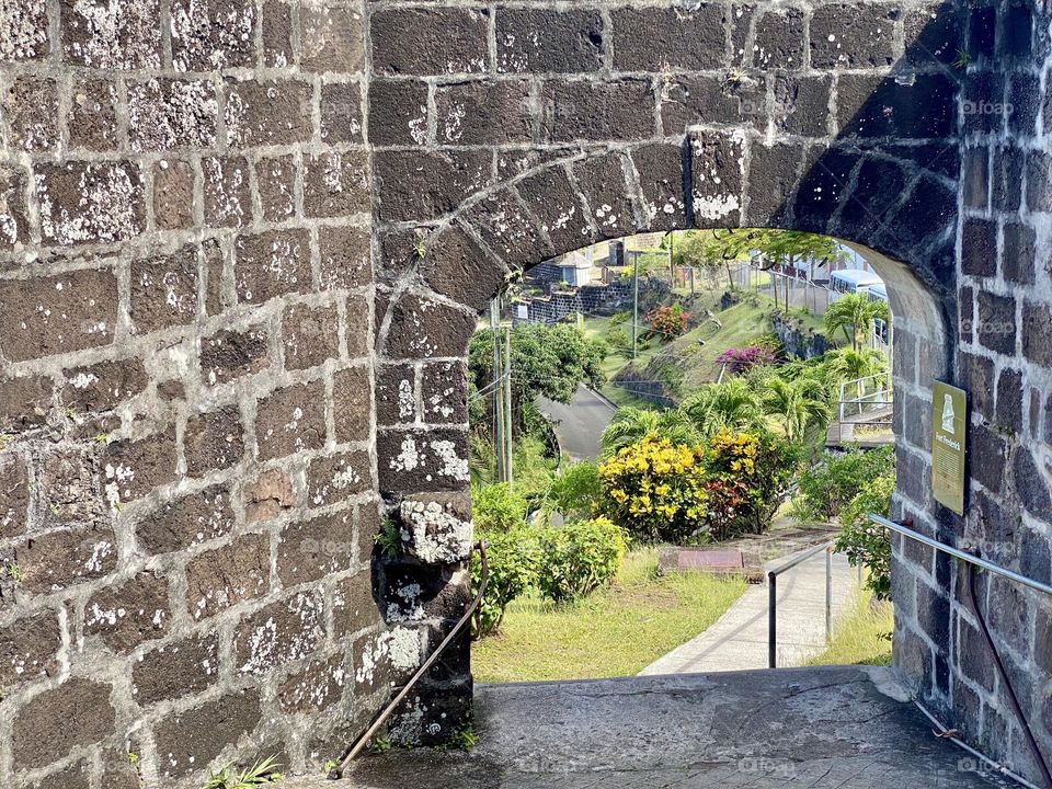 Looking through the opening in a fort towards beautiful gardens 