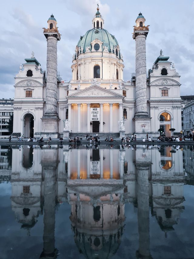 church reflection in the water, with clouds above