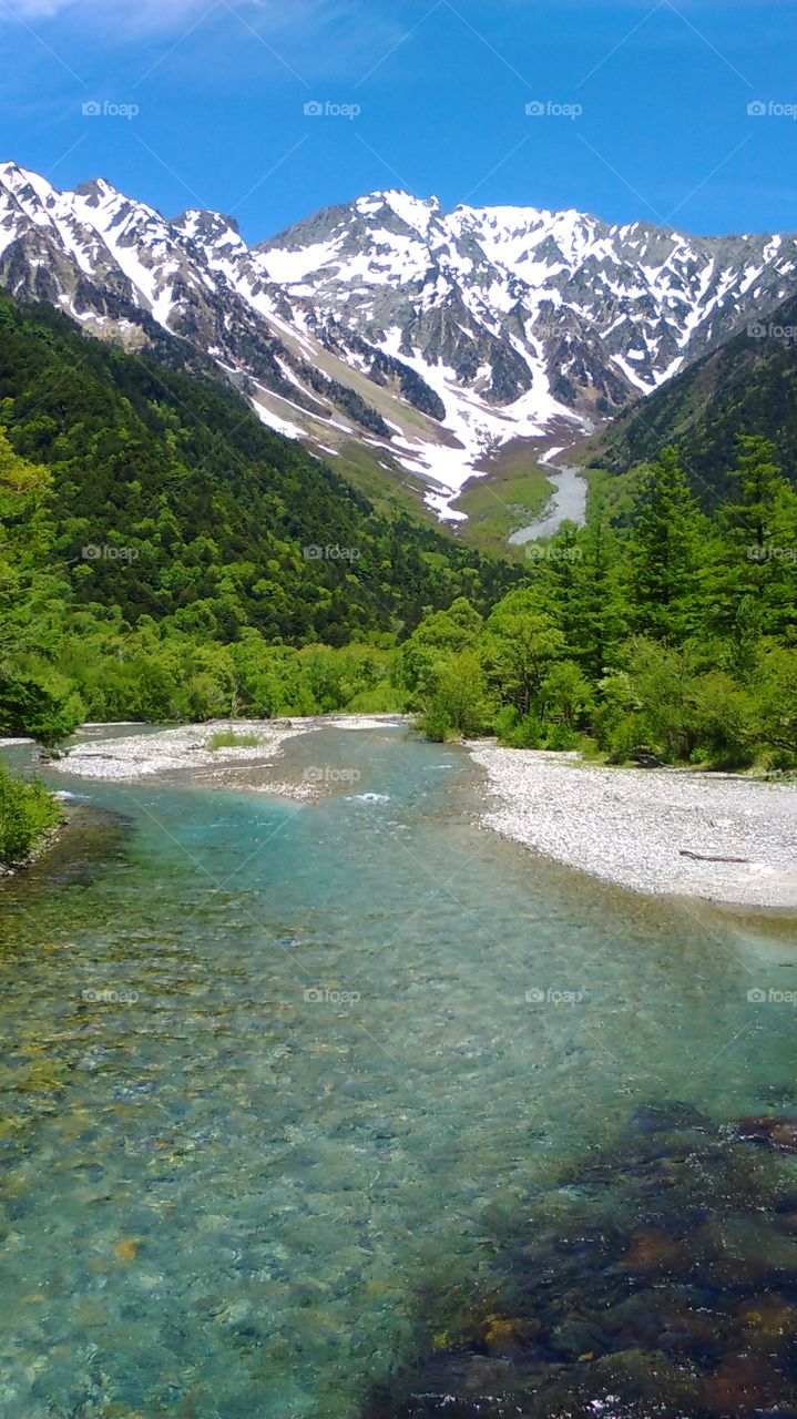 A perfect mountain scene! Snowy mountains and pristine blue waters in Kamikochi Japan.