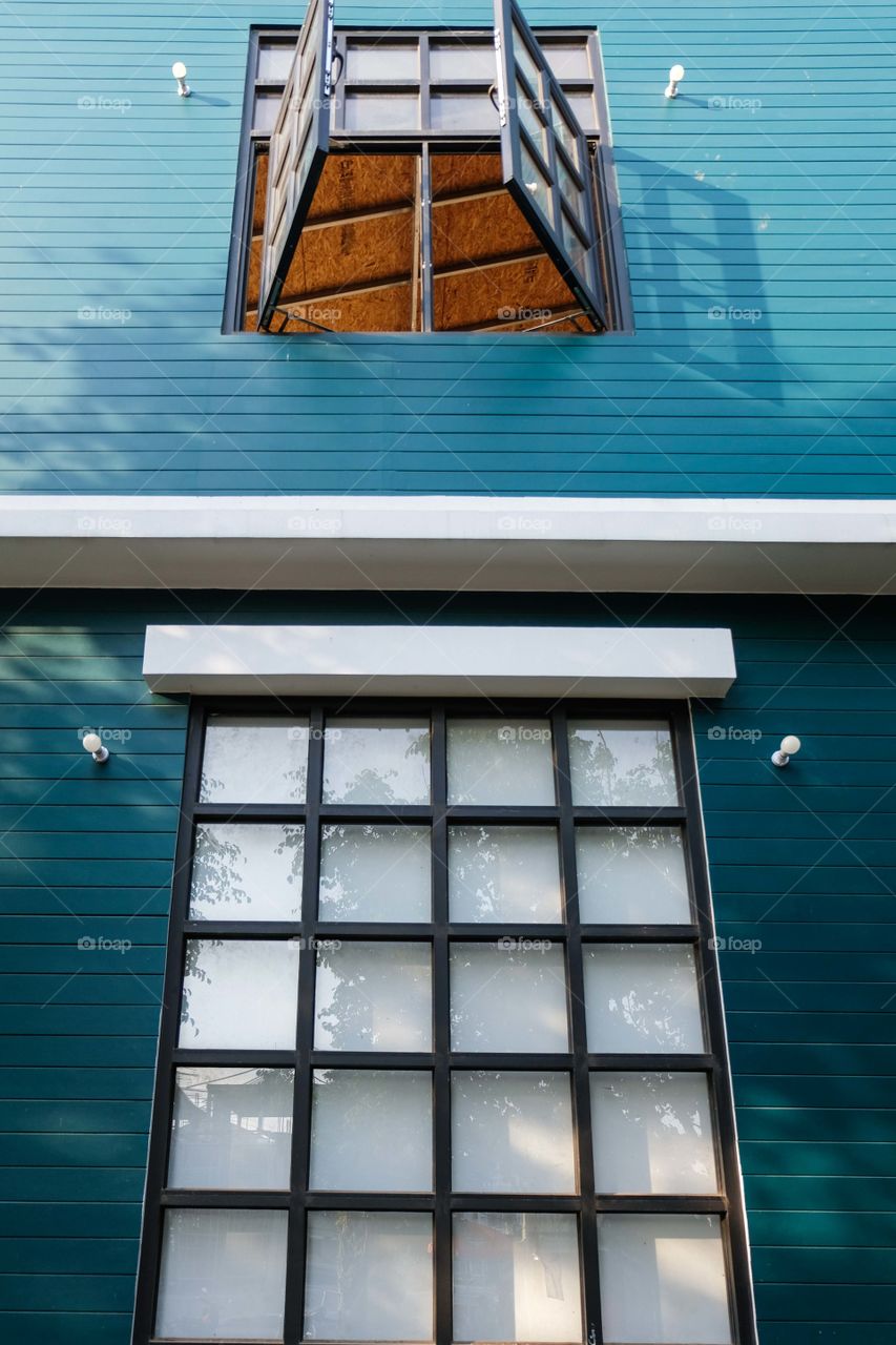 Blue wooden house with two windows above each other 