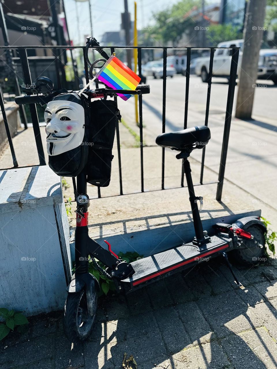 Rainbow small flag at a bike on a big city in day. LGBT symbol, freedom. 