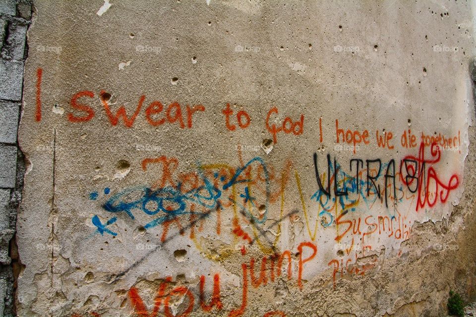 Bosnian graffiti. This poignant message was written on a wall in Mostar, Bosnia. The holes in the walls are from bullets.