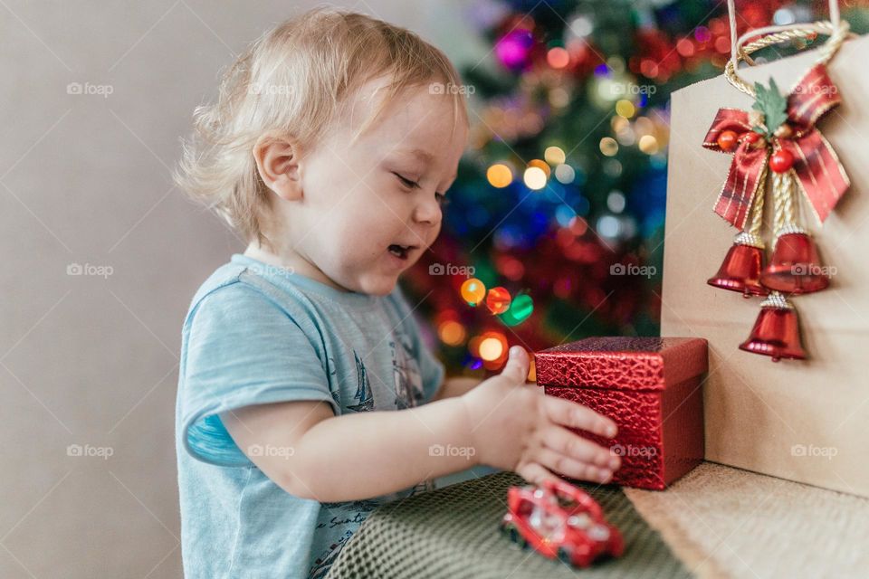 little boy opens a new year gift