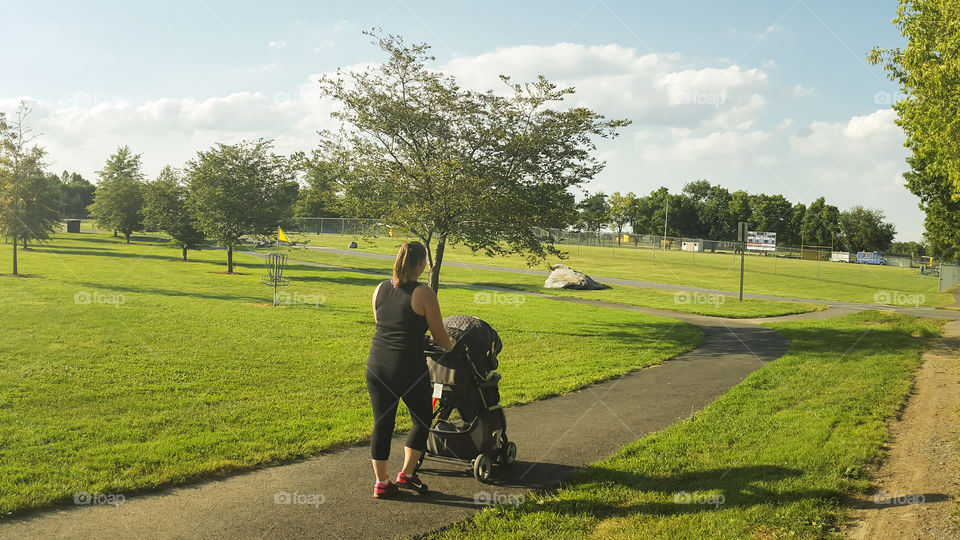 Mom and baby stroll. mom and baby out for an afternoon stroll in local park