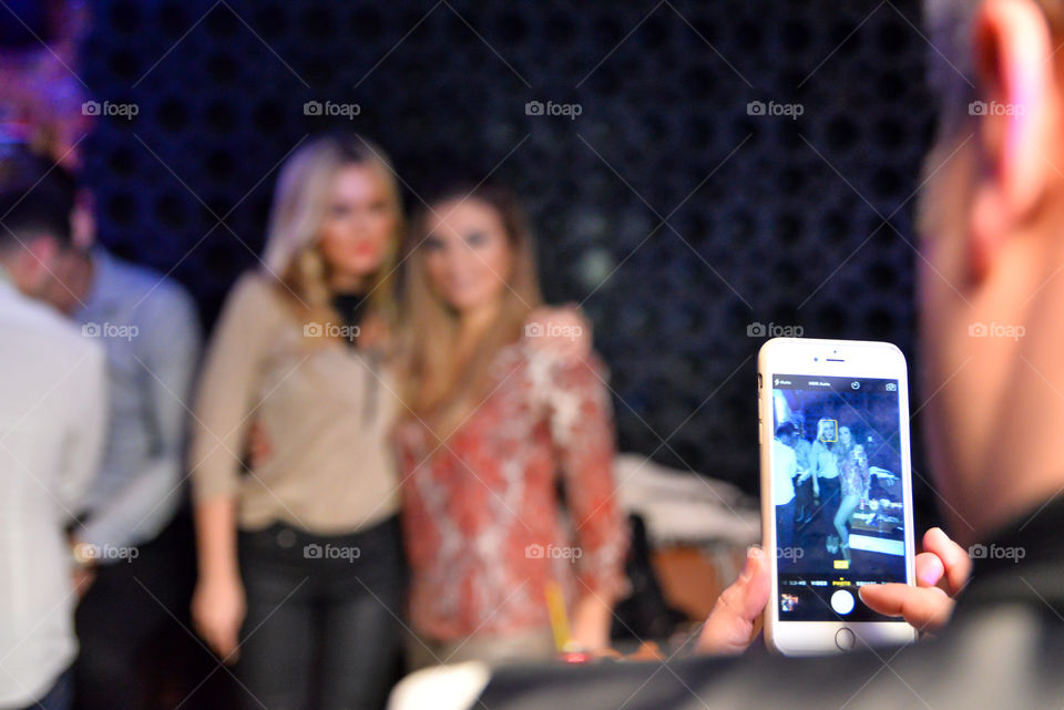 Boy taking a photo of two girls