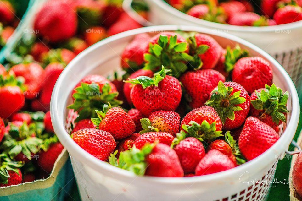 Strawberries in plastic basket at market