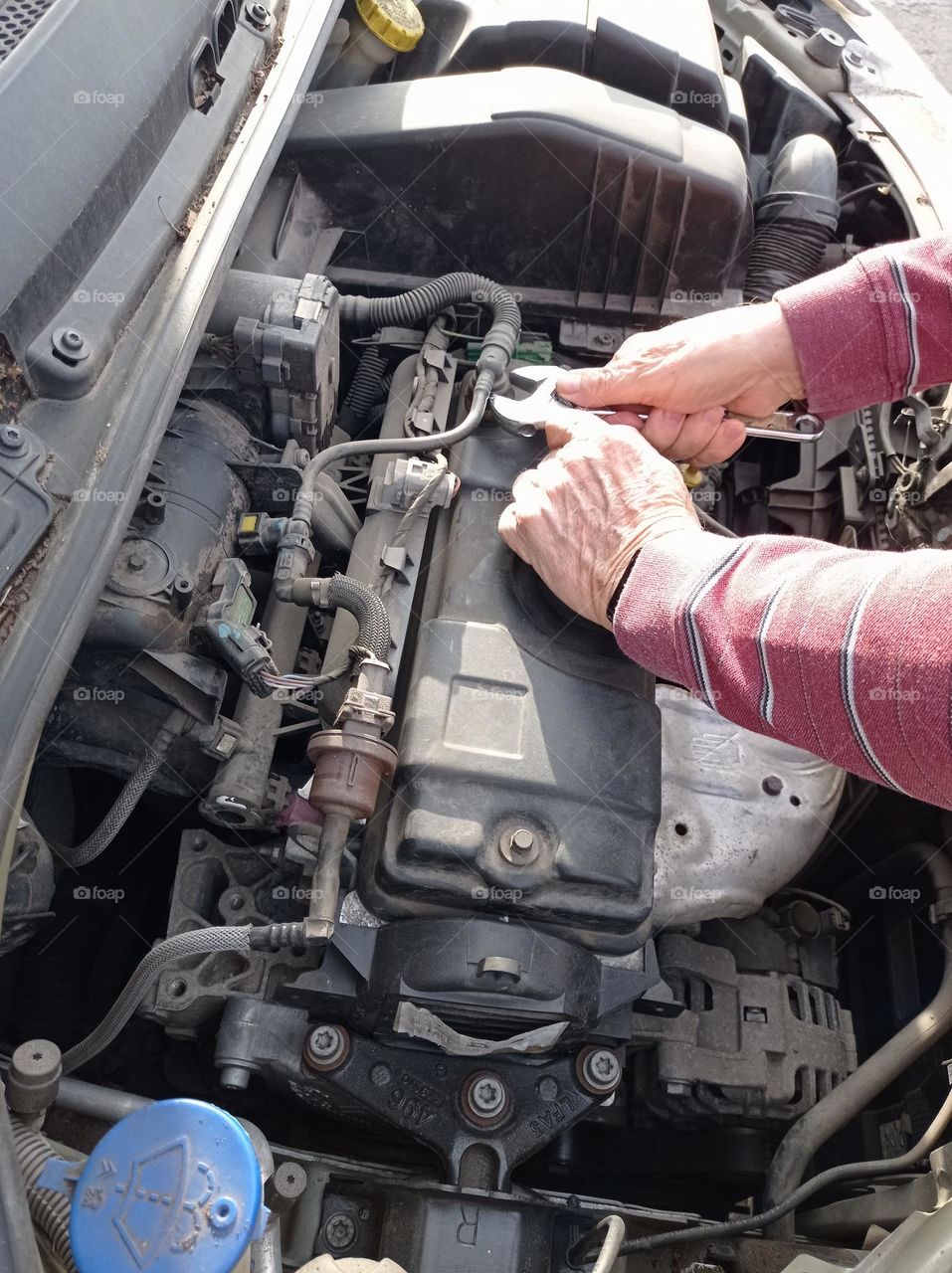 car motor and mechanic's hands / motor de auto y manos del mecánico