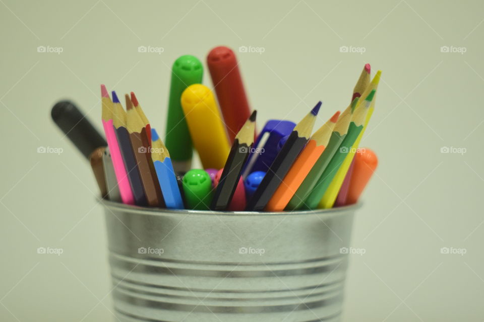 colored pencils and felt pens in a bucket