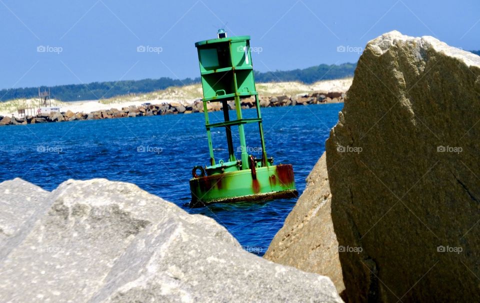 View of a buoy between rocks  in the water
