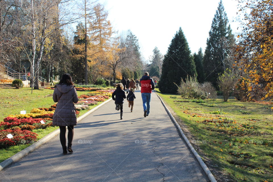 mother walking and father and the kids running on the street