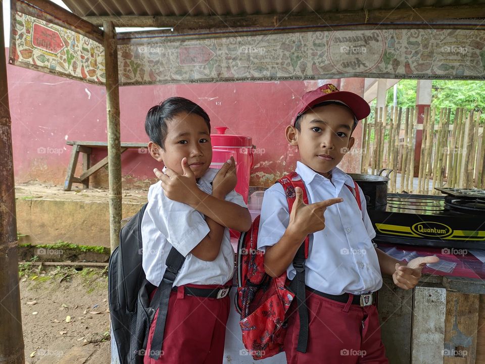 elementary school children who are enjoying their break time at the stall