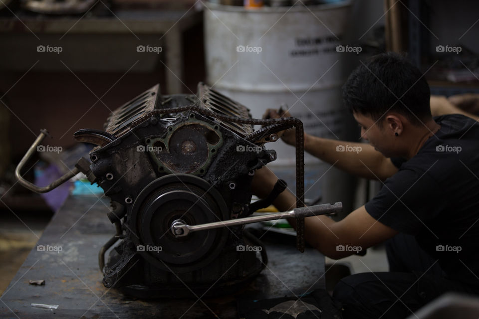 Technician fixing the engine car in the garage