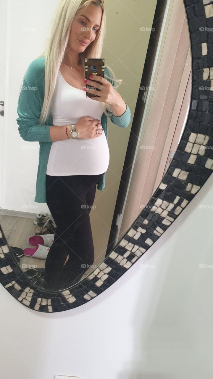 pregnant young woman taking a selfie in the mirror, photo of pregnant women