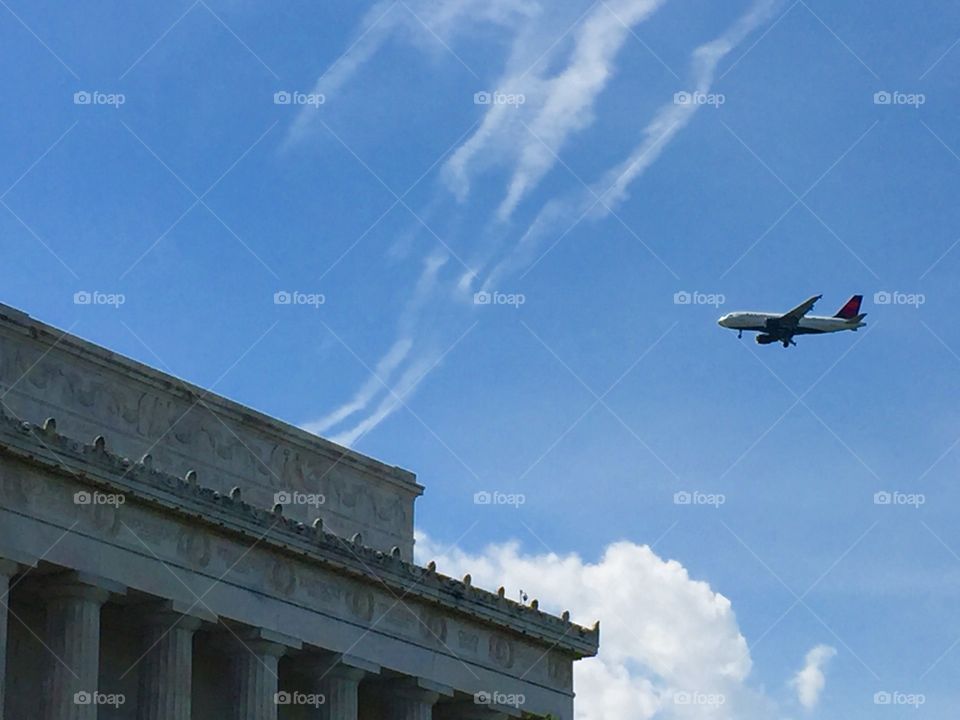 An Airplane flying passing by The Lincoln Memorial Building of Washington DC 