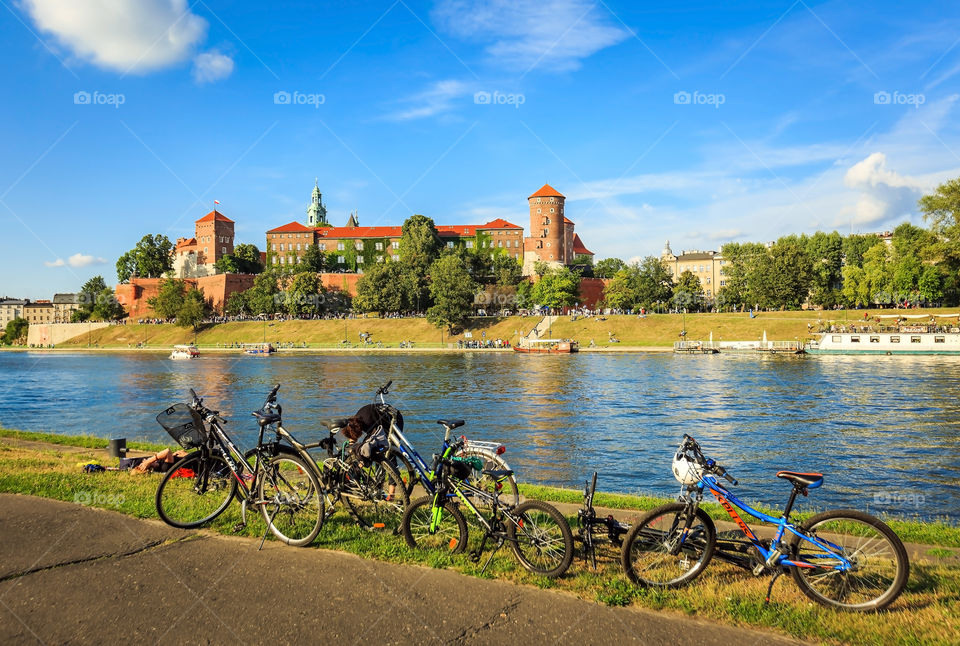 Biking pit stop by river Vistula in Krakow with stunning view of Wawel castle, Poland in summertime