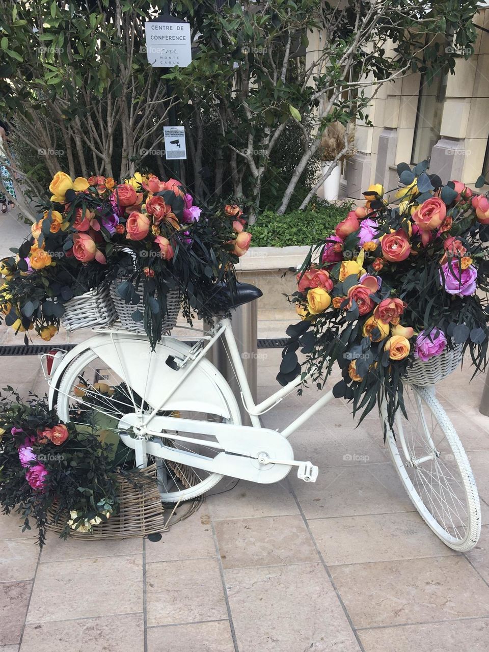 Old bicycle with flowers and white painting recycled in decorative purpose